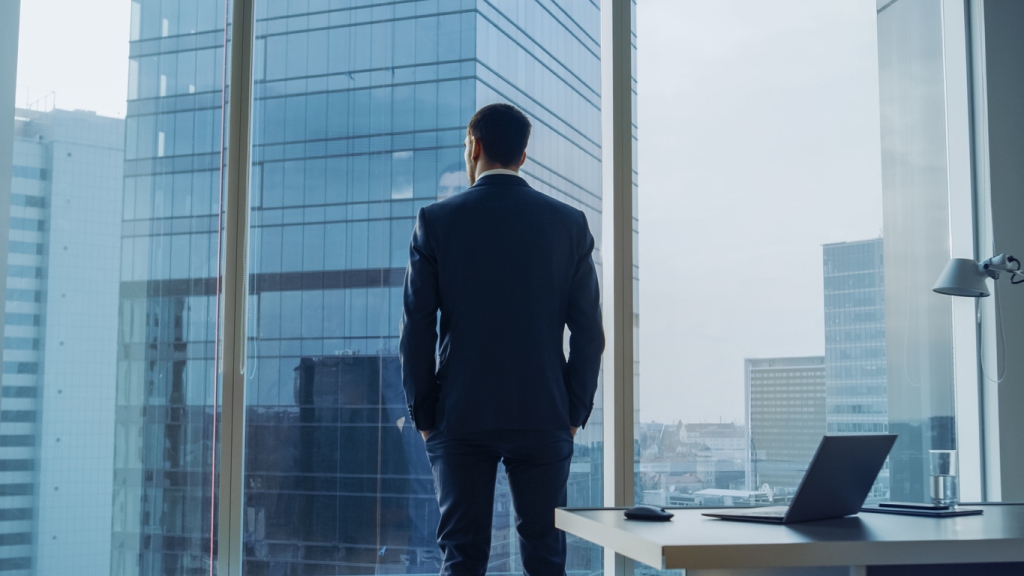 man in suit looking out window | GARNET CAPITAL ADVISORS