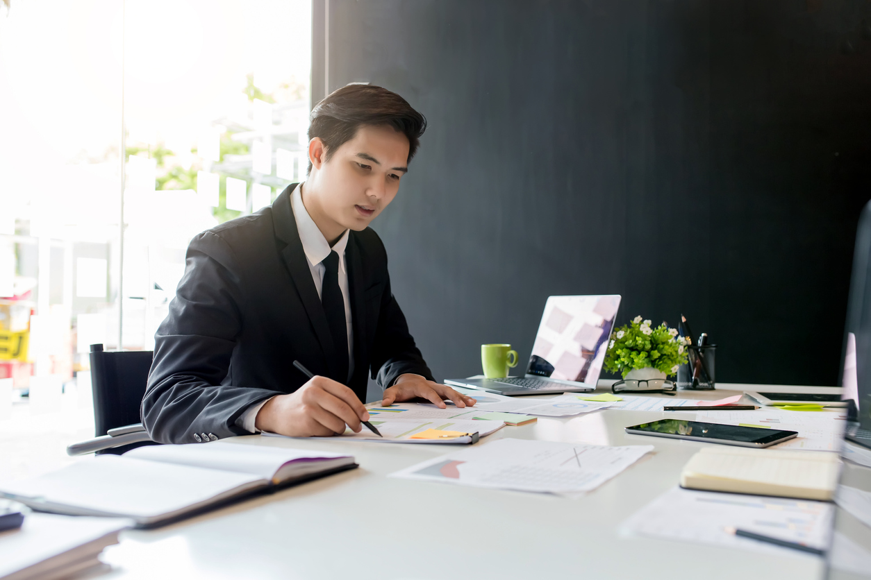 Businessman sitting at desk | GARNET CAPITAL ADVISORS