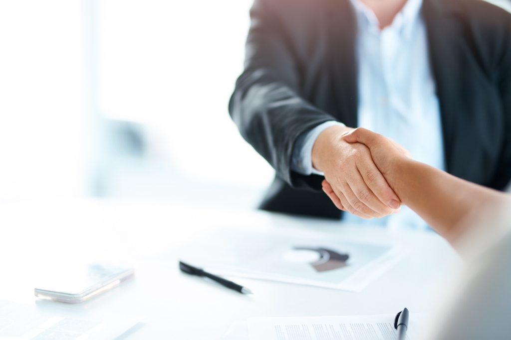 Male financial advisor shaking hands with a client - assisting with loan sales.
